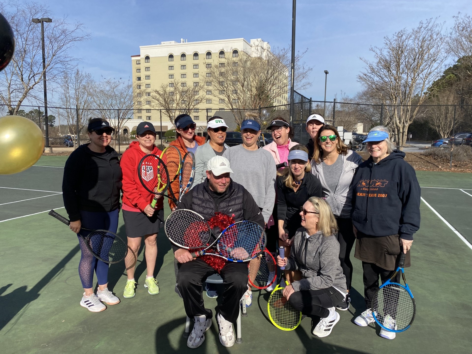Mark with a large group of adult players celebrating at a Love Tennis clinic