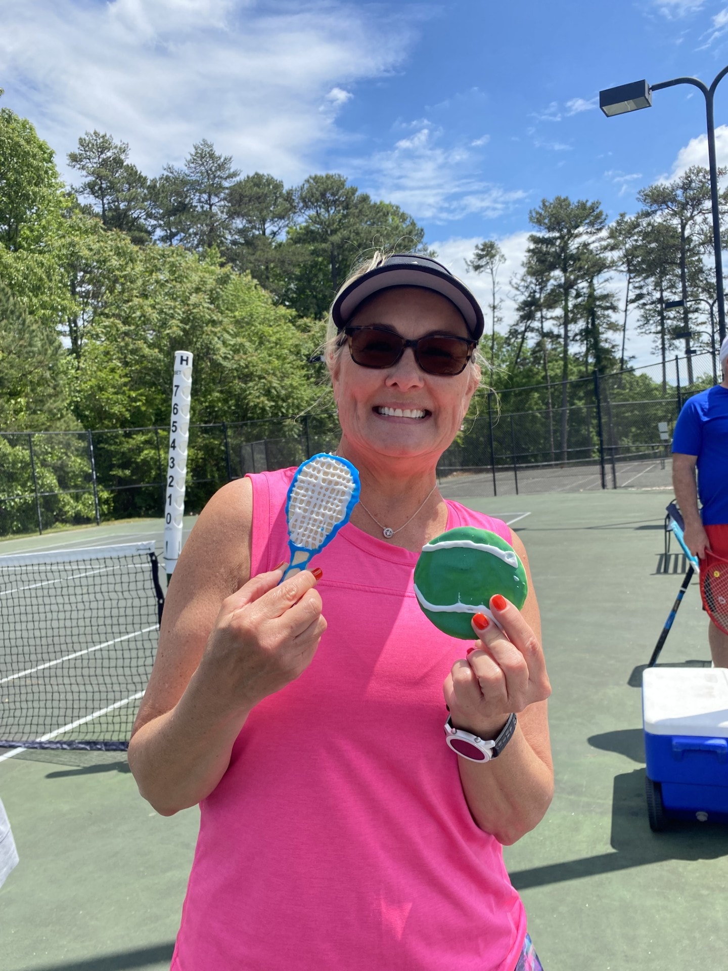 A player holding tennis-themed cookies shaped like a racket and ball at a GTL social event