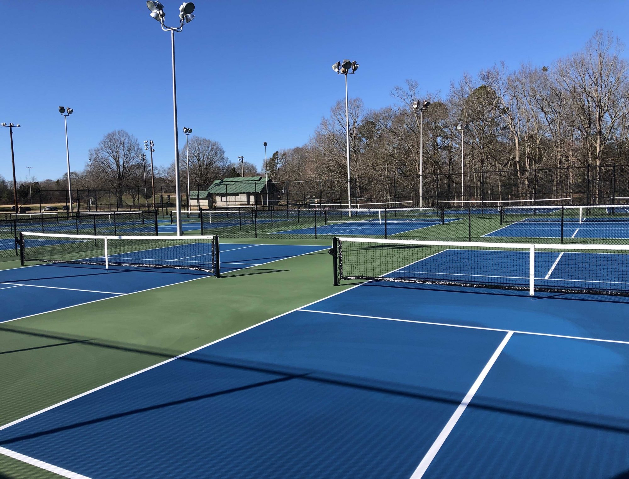 Southside Park tennis courts on a clear day — blue and green hard courts with lights